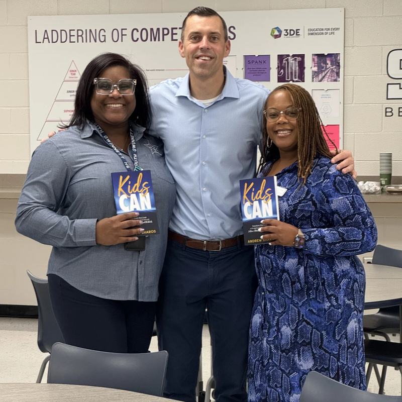 Andrew Sharos with two educators, each holding a copy of Kids Can