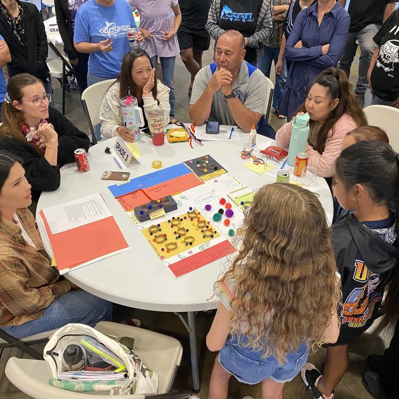 Educators and students working through a hands-on activity at a round table