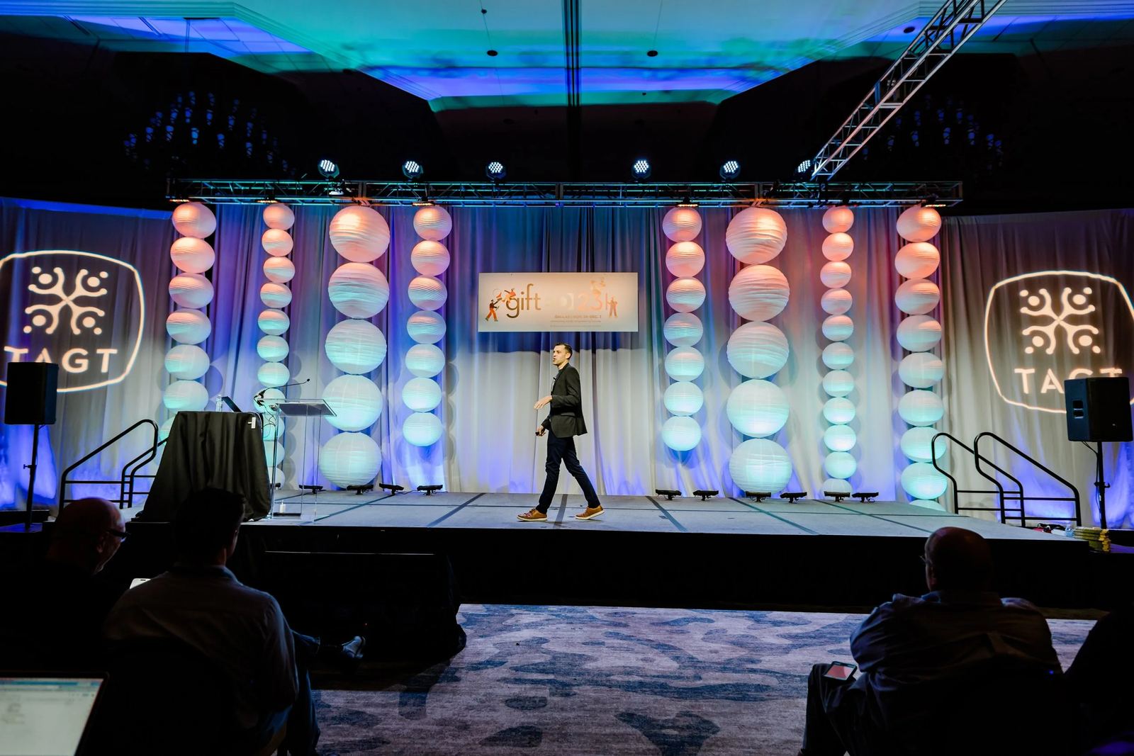 Andrew Sharos on a conference stage, seen from the audience